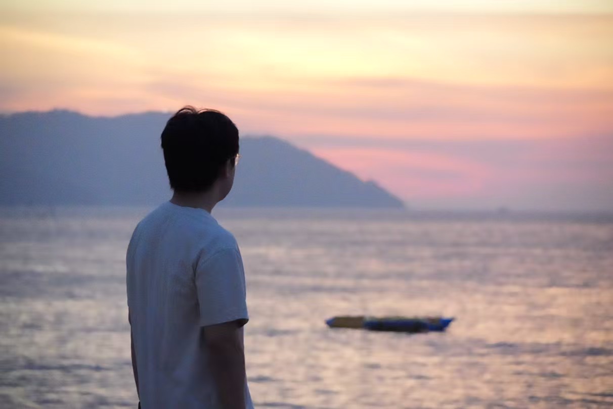 Qiming Zhu watching the sunset by the sea